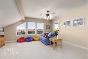 Living area featuring ceiling fan, carpet flooring, a textured ceiling, and vaulted ceiling with beams