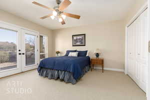 Carpeted bedroom featuring french doors, access to outside, ceiling fan, and a closet