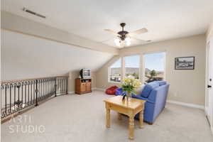 Sitting room with lofted ceiling with beams, carpet, a textured ceiling, and ceiling fan