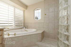 Bathroom with a relaxing tiled tub and vanity