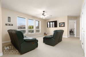 Carpeted living room featuring ceiling fan