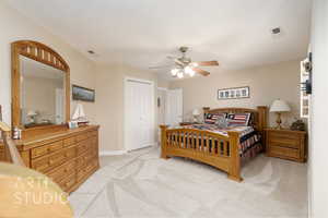 Bedroom with light colored carpet, a closet, and ceiling fan