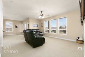 Living room with light carpet, a textured ceiling, and ceiling fan