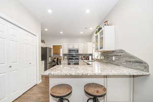 Kitchen with sink, a kitchen breakfast bar, kitchen peninsula, and appliances with stainless steel finishes