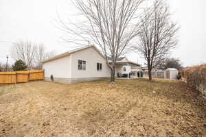 View of property exterior featuring a shed, a yard, and a patio area