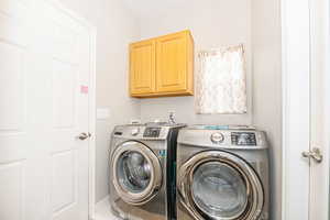 Washroom with cabinets and washing machine and dryer