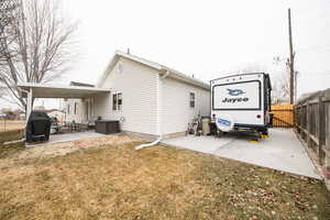 Back of house with central AC, a yard, an outdoor hangout area, and a patio