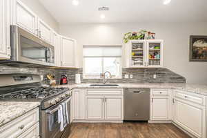 Kitchen featuring white cabinetry, appliances with stainless steel finishes, and sink