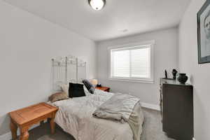 Bedroom featuring carpet and a textured ceiling