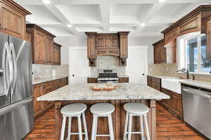 Kitchen featuring stainless steel appliances, a kitchen island, and dark hardwood / wood-style flooring