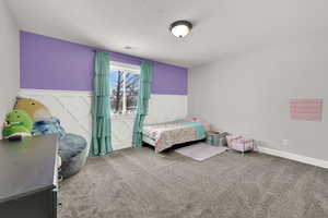 Bedroom featuring carpet floors and a textured ceiling