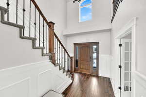 Entrance foyer with a high ceiling and dark hardwood / wood-style floors