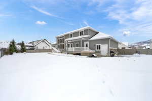 Snow covered property with a hot tub and a sunroom