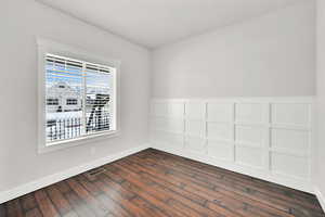 Unfurnished room featuring dark wood-type flooring