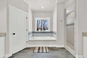 Bathroom featuring vanity and shower with separate bathtub