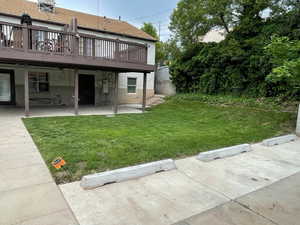 View of back yard with a wooden deck and a patio area