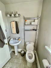 Unit 4 Bathroom featuring toilet, tile patterned flooring, and a baseboard heating unit