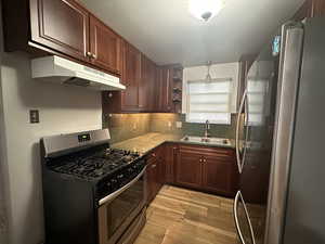 Unit 2 Kitchen with sink, decorative backsplash, light hardwood / wood-style floors, and appliances with stainless steel finishes