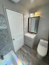 Unit 2 Bathroom with hardwood / wood-style flooring, vanity, and toilet