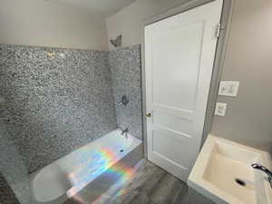 Unit 2 Bathroom with shower / tub combination, sink, and hardwood / wood-style floors