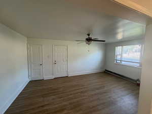 Unit 1 Family room with ceiling fan, a baseboard heating unit, and dark hardwood / wood-style flooring