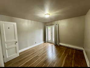 Unit 4 bedroom #1 with wood-type flooring and baseboard heating