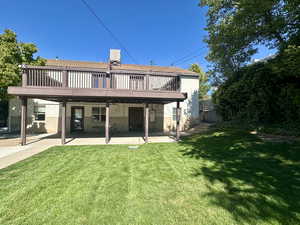 Rear view of house featuring a yard, a patio area, and a deck