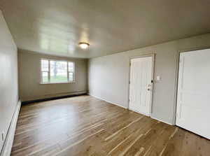 Unit 2 Living room space featuring baseboard heating and light hardwood / wood-style flooring