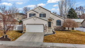 View of front property featuring a garage and a front yard