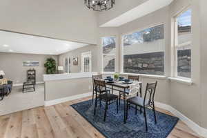 Dining area with a chandelier, light hardwood / wood-style floors, and a wealth of natural light