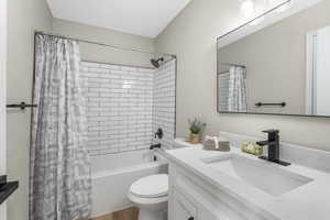 Full bathroom with shower / tub combo with curtain, vanity, and toilet