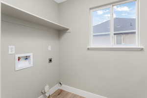 Washroom featuring hookup for a washing machine, hookup for an electric dryer, and light wood-type flooring