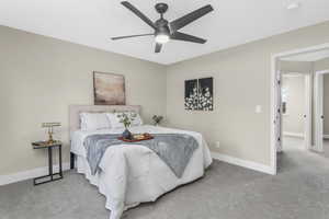 Bedroom with ceiling fan and light carpet