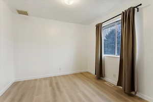 Empty room with light hardwood / wood-style floors