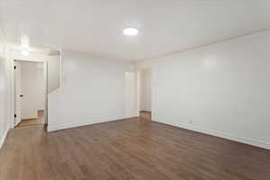 Spare room featuring dark wood-type flooring