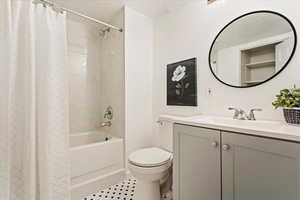 Full bathroom with shower / tub combo, vanity, toilet, and tile patterned flooring