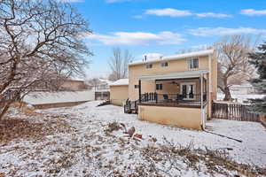 Snow covered rear of property featuring ceiling fan