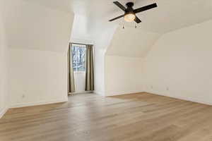 Bonus room with lofted ceiling, light hardwood / wood-style floors, and ceiling fan