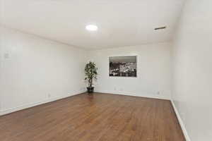 Spare room featuring dark wood-type flooring