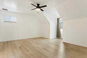 Bonus room featuring ceiling fan, lofted ceiling, and light wood-type flooring