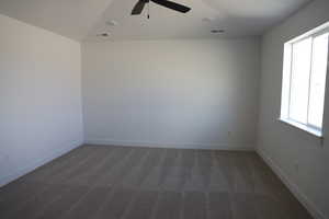 Carpeted spare room featuring ceiling fan and plenty of natural light