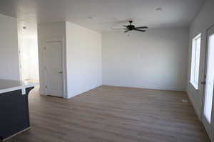 Spare room featuring ceiling fan, light hardwood / wood-style floors, and a wealth of natural light