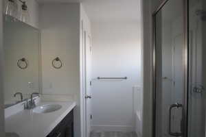 Bathroom featuring vanity, hardwood / wood-style floors, and separate shower and tub