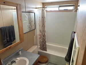 Full bathroom with vanity, shower / tub combo, and toilet