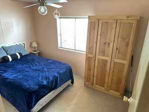 Carpeted bedroom featuring ceiling fan