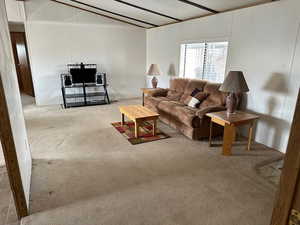 Living room featuring carpet floors and beam ceiling