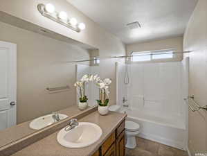 Full bathroom featuring toilet, tub / shower combination, a textured ceiling, vanity, and tile patterned flooring