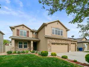 View of front of house featuring 3rd car garage, a front lawn, and covered porch