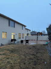 Back of property with a lawn and a patio