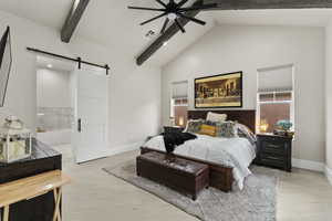 Primary Bedroom with beam ceiling, light hardwood / wood-style flooring, a barn door, and ensuite bathroom